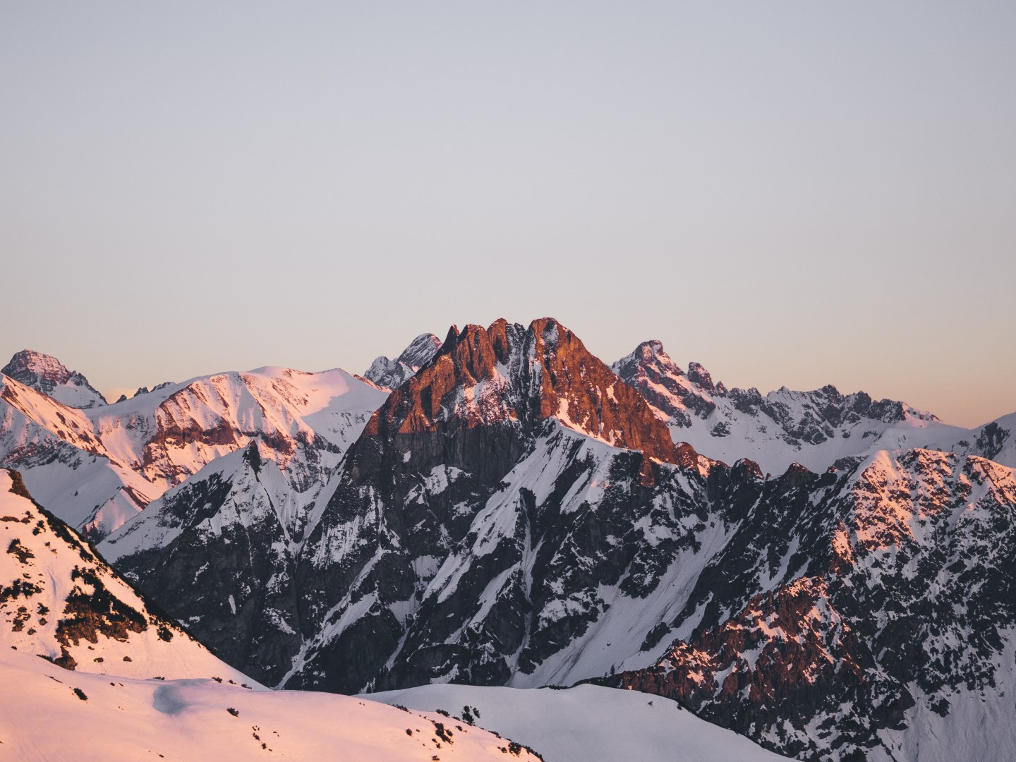 Alpenpark Neuss in Germany - a snow covered mountain range at sunset.