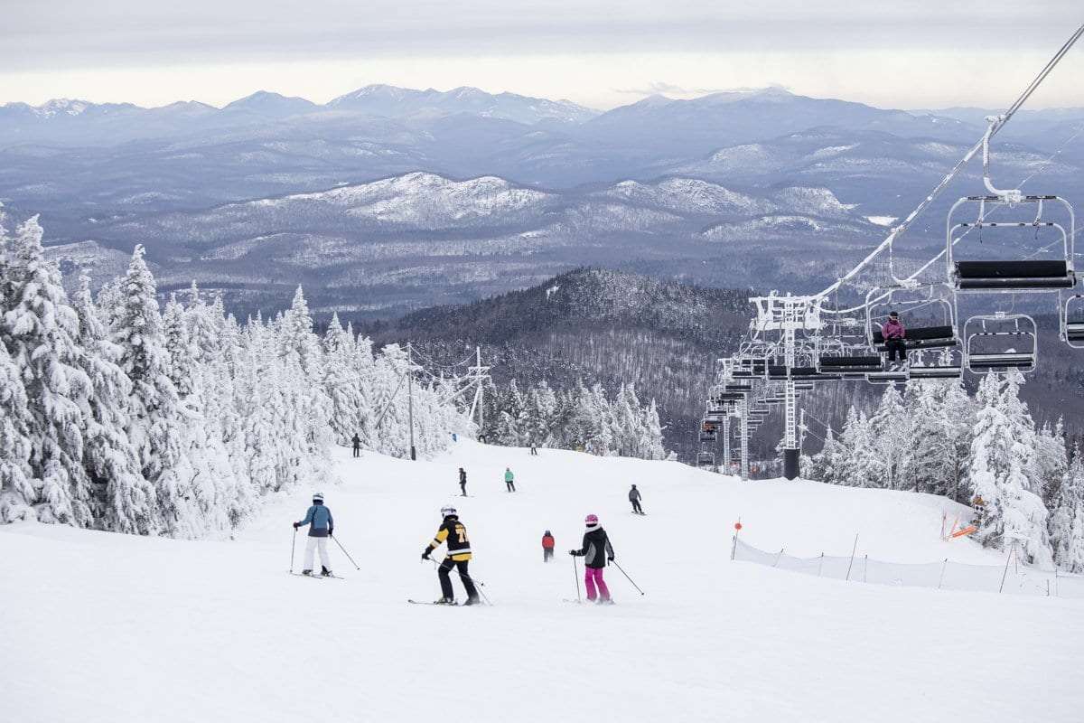 Gore Mountain, The Adirondacks, North Creek, USA, group of skiers and snowboarders on the slope underneath the chairlift