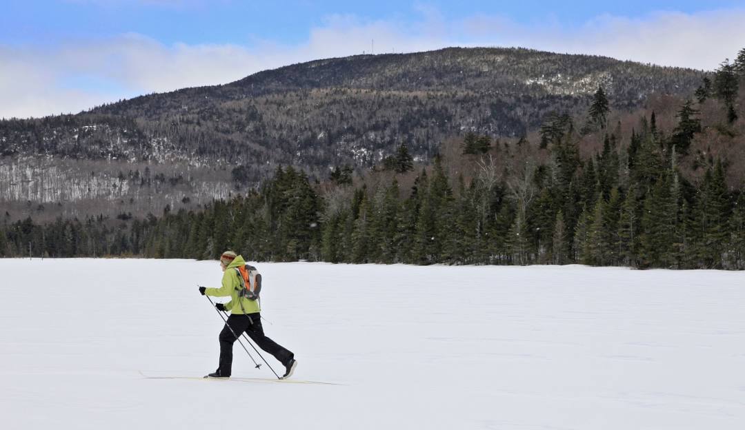 Gore Mountain in USA - a man cross country skiing on a snow covered lake.