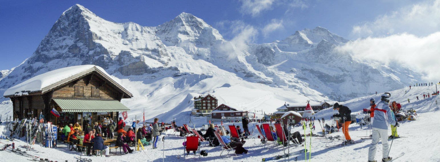 Grindelwald First in Switzerland - a group of people standing on top of a snowy mountain.