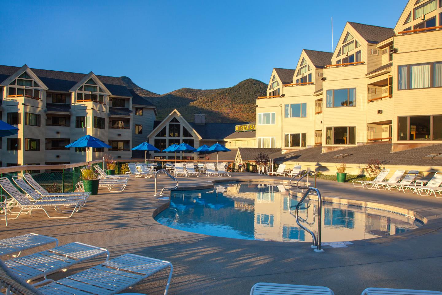 Loon Mountain Resort in USA - an outdoor swimming pool with lounge chairs and umbrellas.