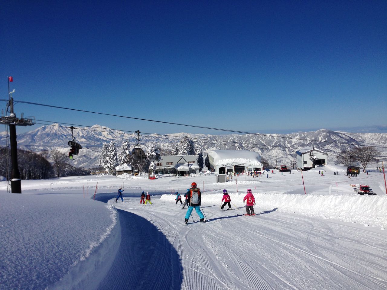 Nozawa Onsen in Japan - a group of people riding down a snow covered slope.