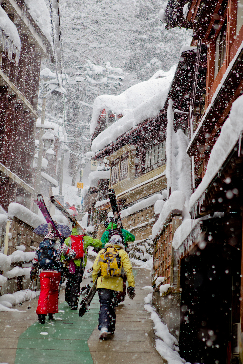 Nozawa Onsen in Japan - a group of people walking down a snow covered street.
