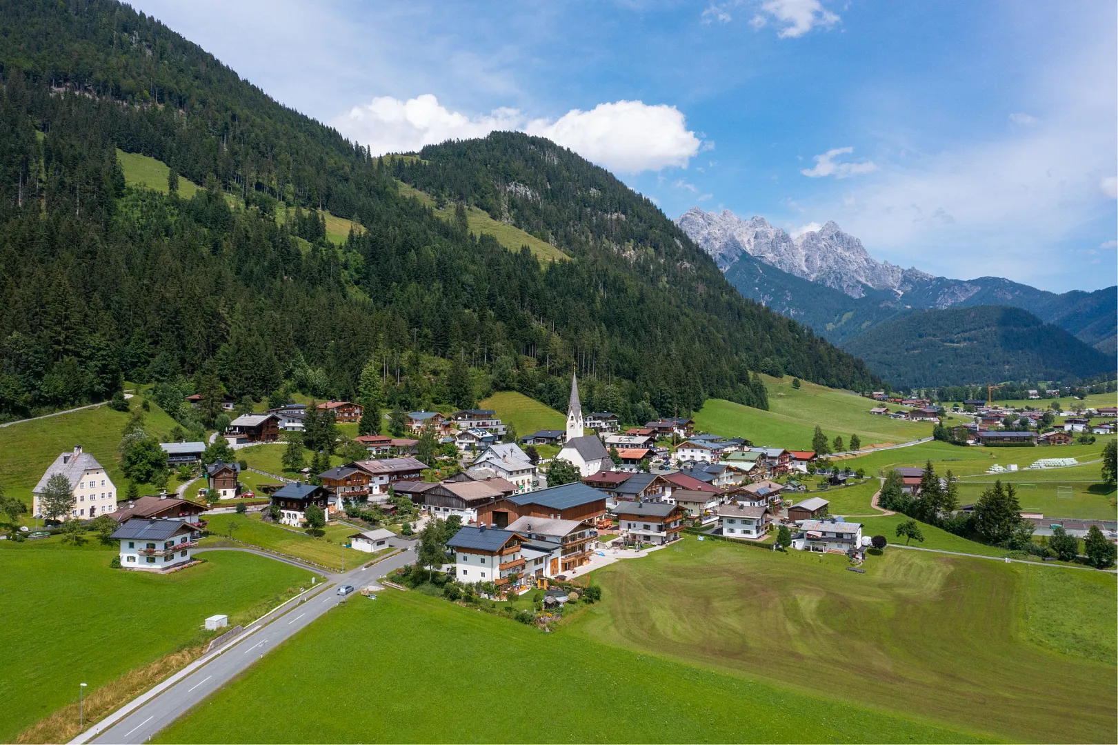 Buchensteinwand – St Ulrich am Pillersee | ​St Jakob in Haus | ​Hochfilzen in Austria - an aerial view of a village in the austrian alps.