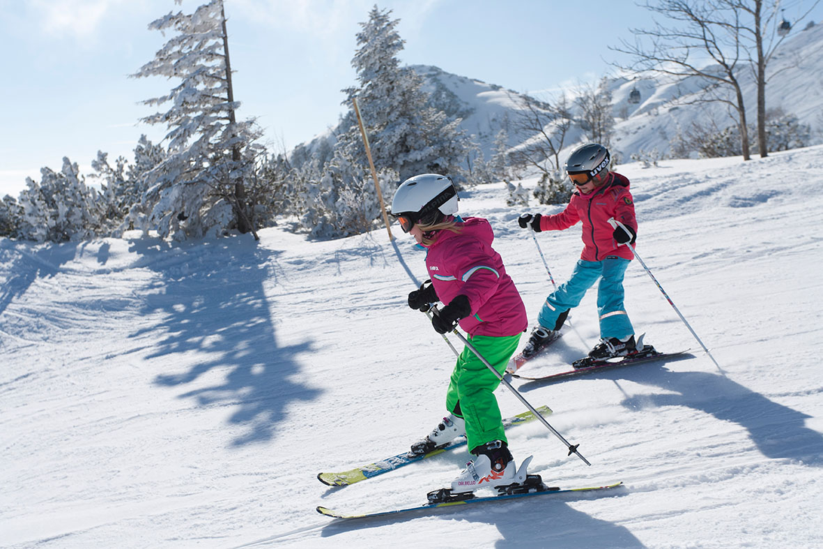 Feuerkogel – Ebensee in Austria - two young girls skiing down a snowy slope.