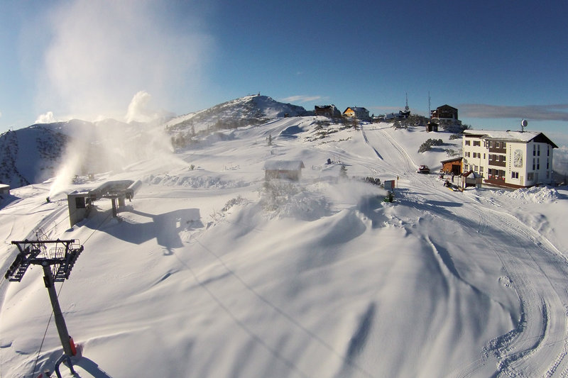 Winter sport enthusiasts engage in invigorating activities at the bustling ski resort of Feuerkogel - Ebensee in Salzkammergut, surrounded by beautiful chalets and stunning winter scenery.