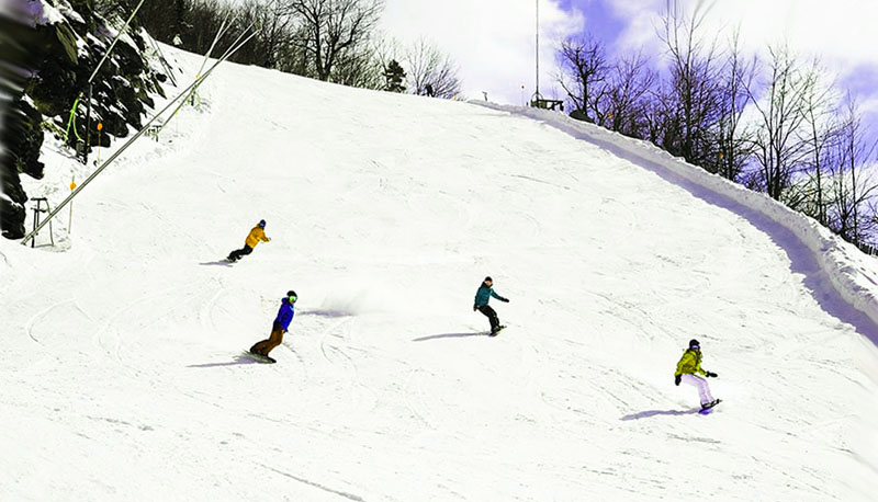 Hunter Mountain in USA - a group of people riding down a snow covered slope.