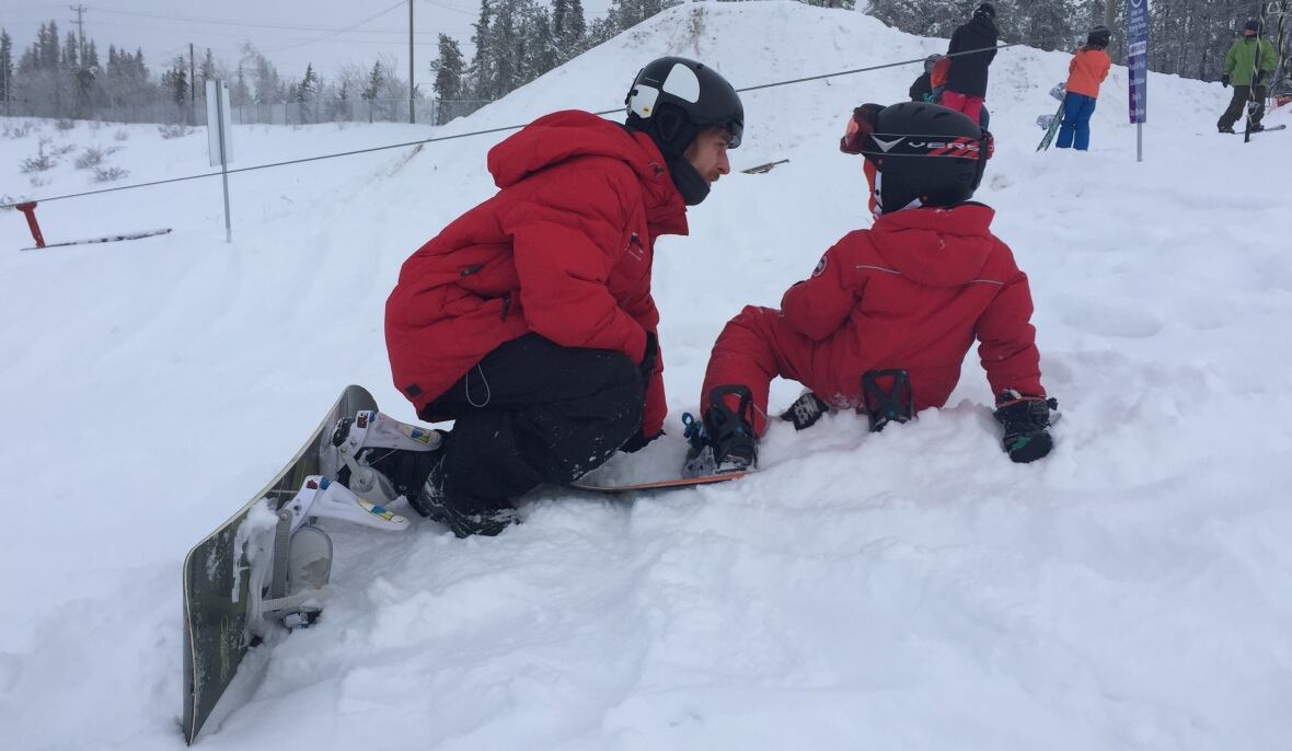 Bristol Pit – Yellowknife in Canada - two children playing in the snow with a snowboard.