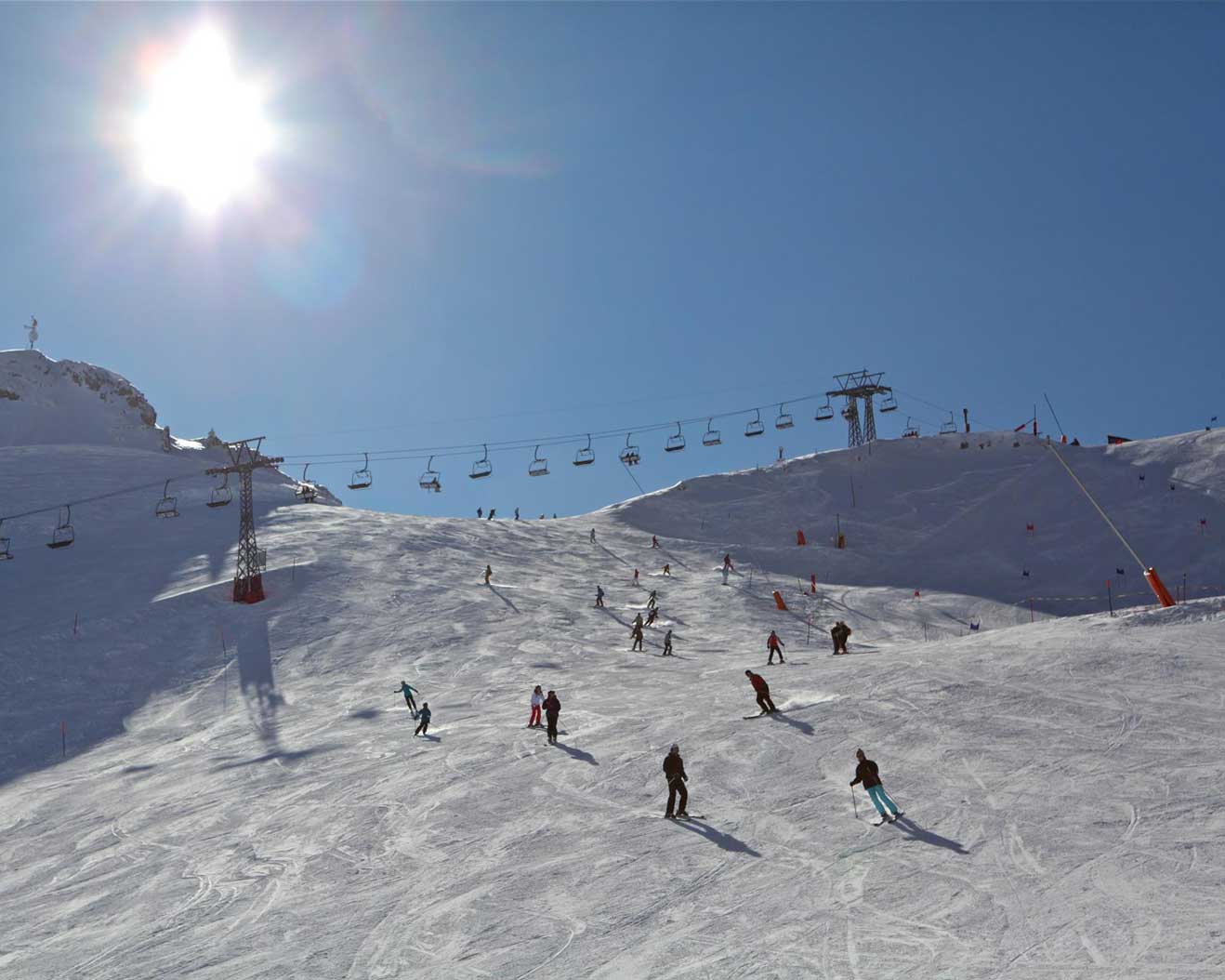 Leysin in Switzerland - a group of people skiing down a snowy slope.