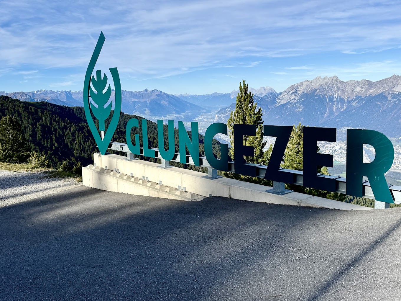 Glungezerbahn in Austria - the sign at the top of the mountain with mountains in the background.