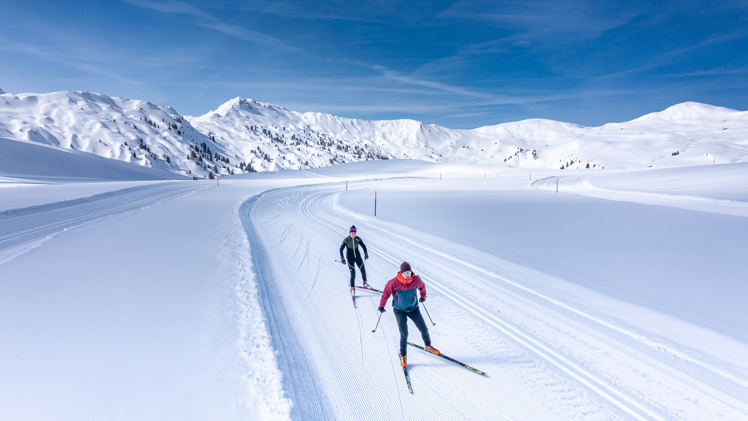 Skiers enjoying winter sports at Betelberg in Bernese Oberland, Switzerland. A family and a group of people can be seen participating in the snowy activities.