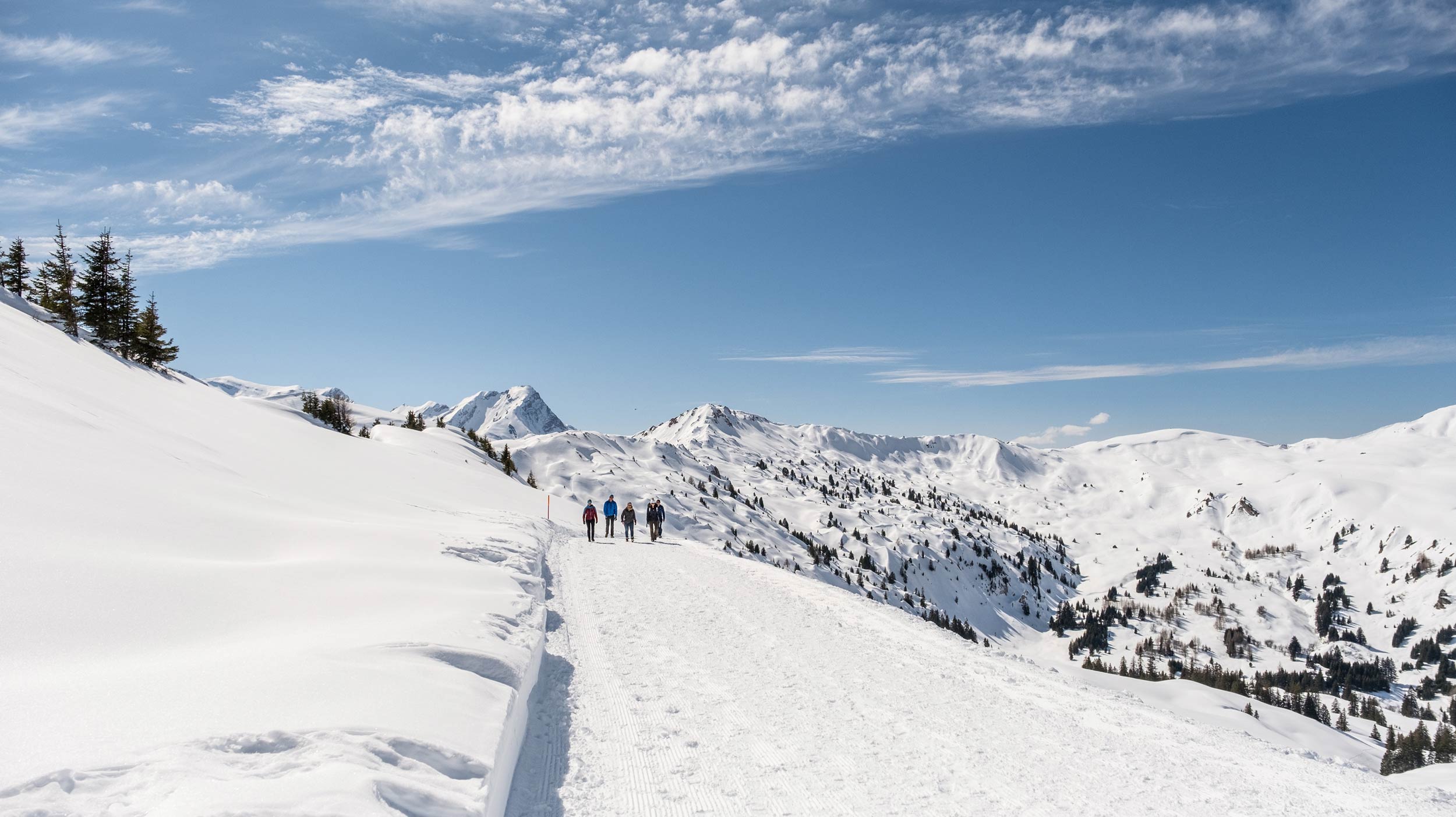 A winter sports scene at Betelberg in Bern, Switzerland, featuring a charming chalet against the backdrop of a snowy mountain, amidst the stunning ski resort landscape.