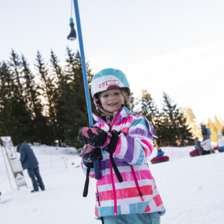 A snowboarder engaged in a thrilling downhill adventure in Charmey, Fribourg, Switzerland, amidst the picturesque setting of the snowy Espace Mittelland region.