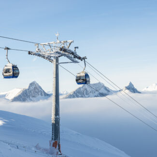 View of Charmey ski resort in Switzerland featuring a ski lift ascending snow-covered slopes. A chalet is visible in the backdrop embodying a vibrant winter sports scene.