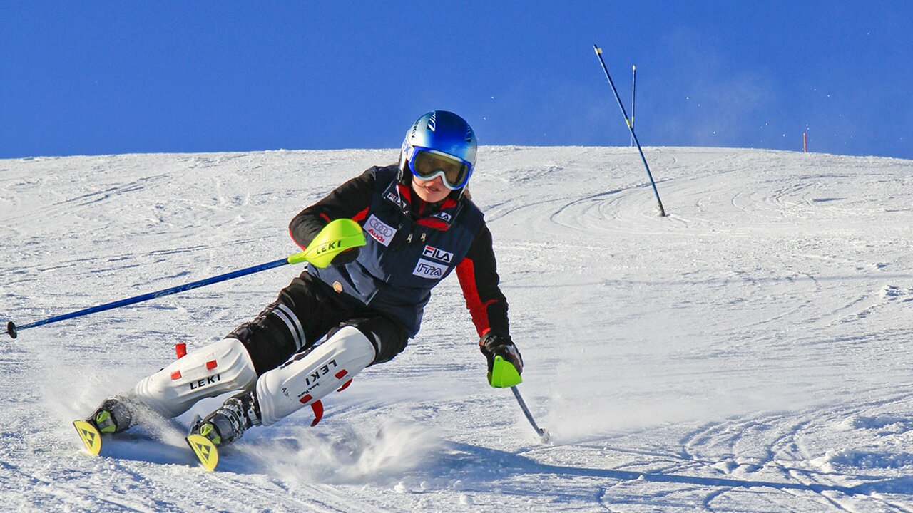Consorzio Pontedilegno-Tonale (Ponte di Legno | ​Tonale | ​Presena Glacier Temù) in Italy - a person on skis going down a hill.