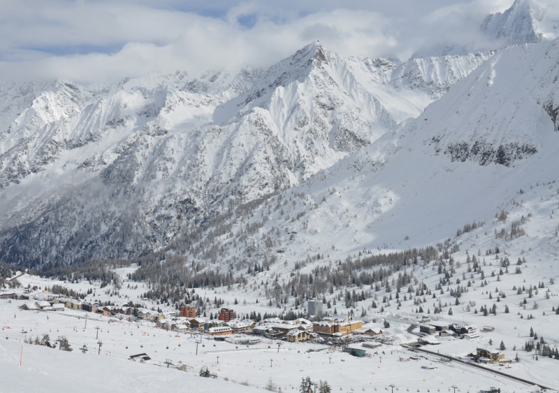 A picturesque chalet scene at the Consorzio Pontedilegno-Tonale ski resort in Trentino-Alto Adige Italy. Winter sports enthusiasts take advantage of the snowy conditions under a ski lift.
