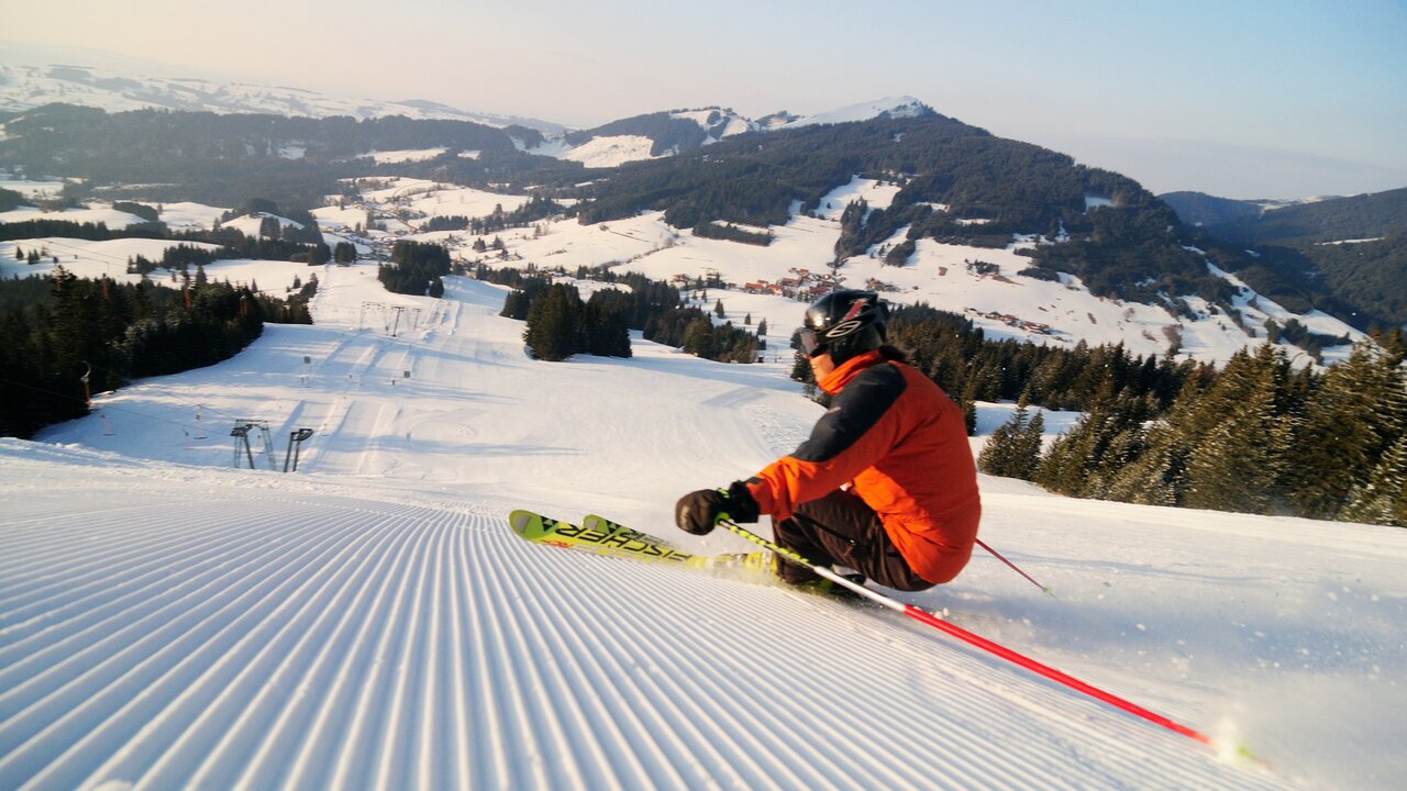 Jungholz in Austria - a person in an orange jacket skiing down a hill.
