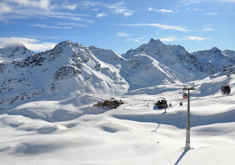 Stunning winter landscape at Santa Caterina Valfurva ski resort in Valtellina, Italy. The scene features a charming chalet amidst a thriving winter sports scene, signifying a vibrant winter sports center.