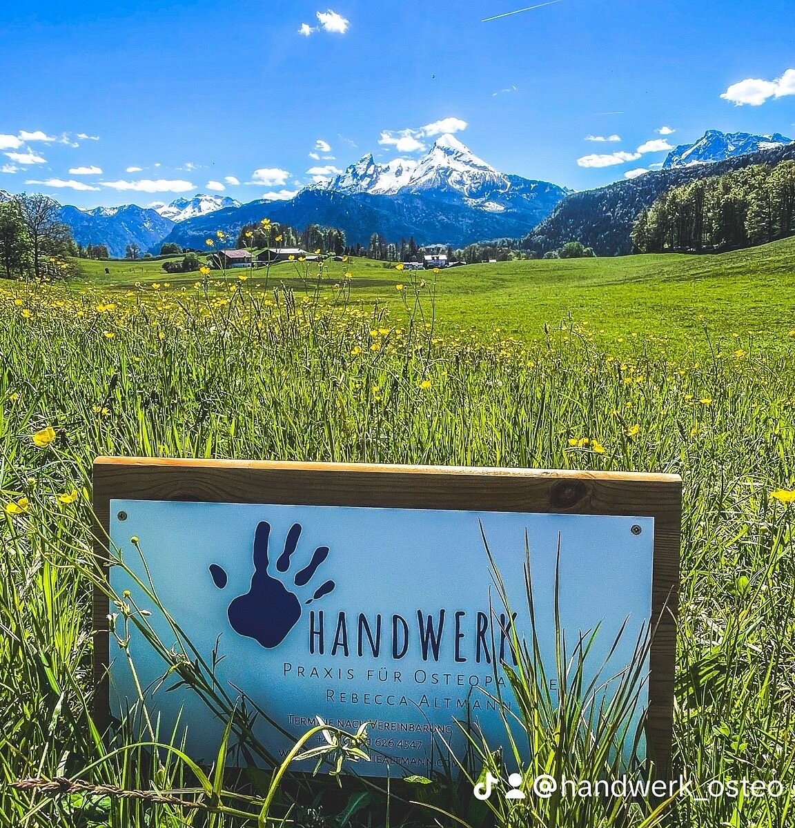 Götschen – Bischofswiesen in Germany - a sign in the middle of a field with mountains in the background.