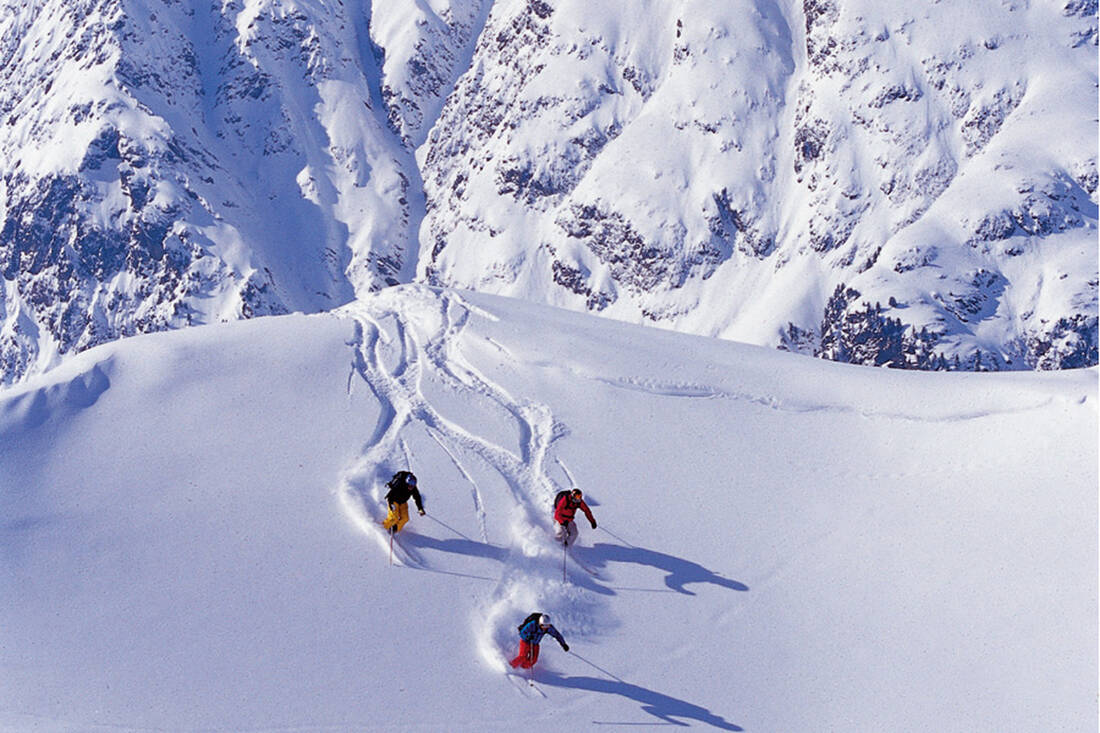 Ischgl Samnaun – Silvretta Arena in Austria - two people skiing down a snowy mountain.