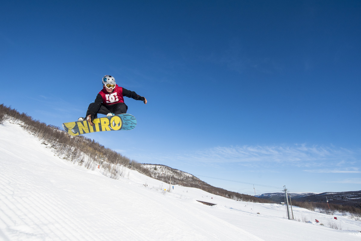 Skarslia in Norway - a man flying through the air while riding a snowboard.