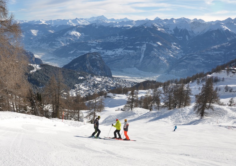 A lively winter sports scene at Ovronnaz ski resort in Switzerland featuring a charming chalet an energetic skier and a family enjoying their skiing adventure in the stunning Lemanic Region.