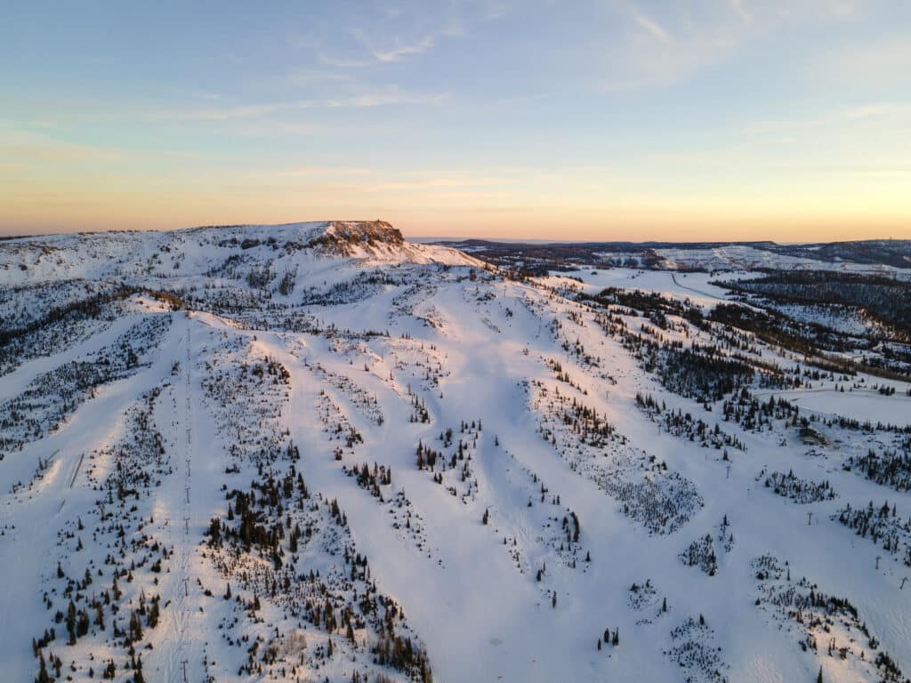 Brian Head in USA - an aerial shot of a snow covered mountain at sunset.