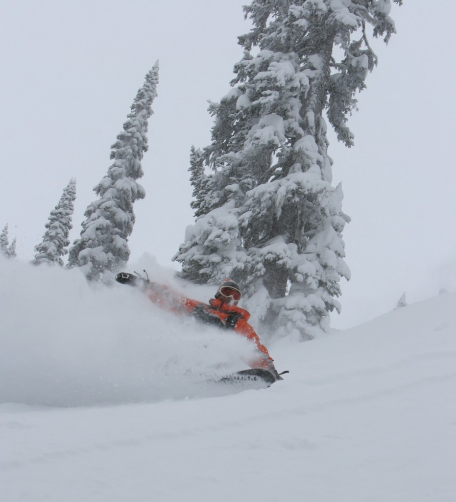 Eagle Pass Heliskiing in Canada - a person riding a snowboard down a snow covered slope.