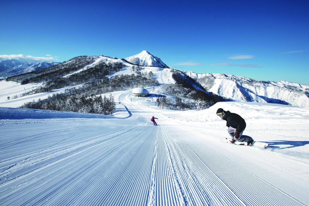 Maiko Snow Resort in Japan - a person on a snowboard going down a hill.