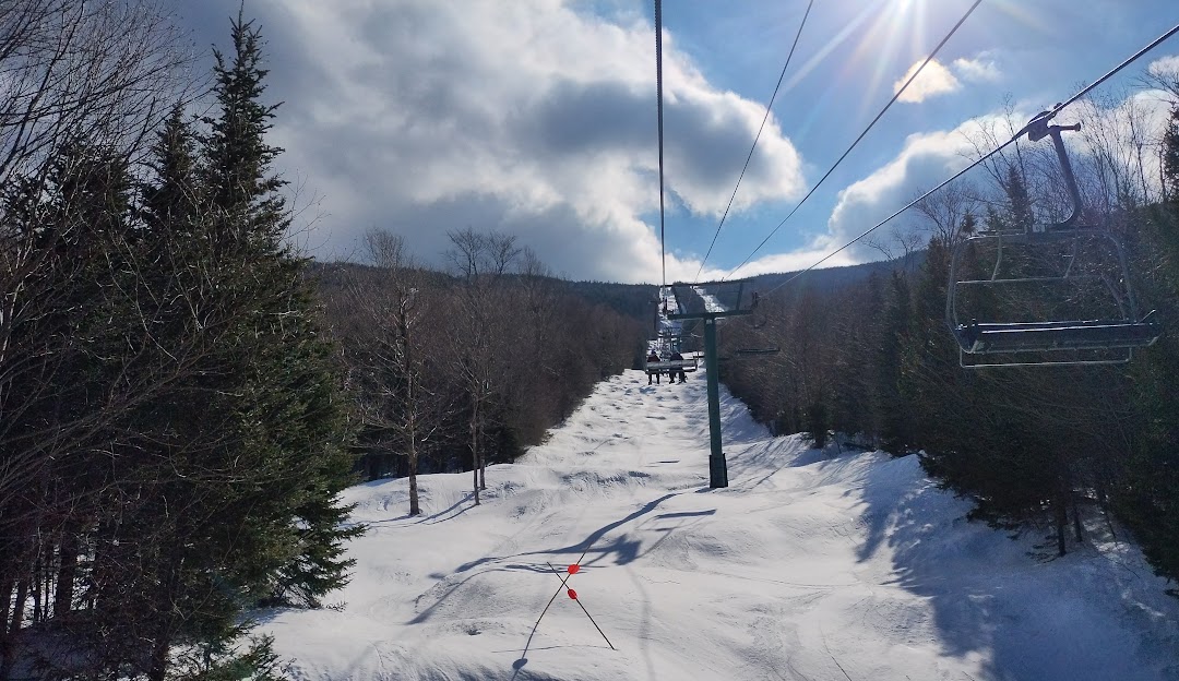Attitash Mountain Resort in USA - a ski lift going down a snowy slope.