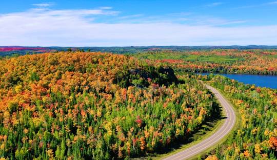 Lutsen Mountains in USA - an aerial view of a road winding through a forest.