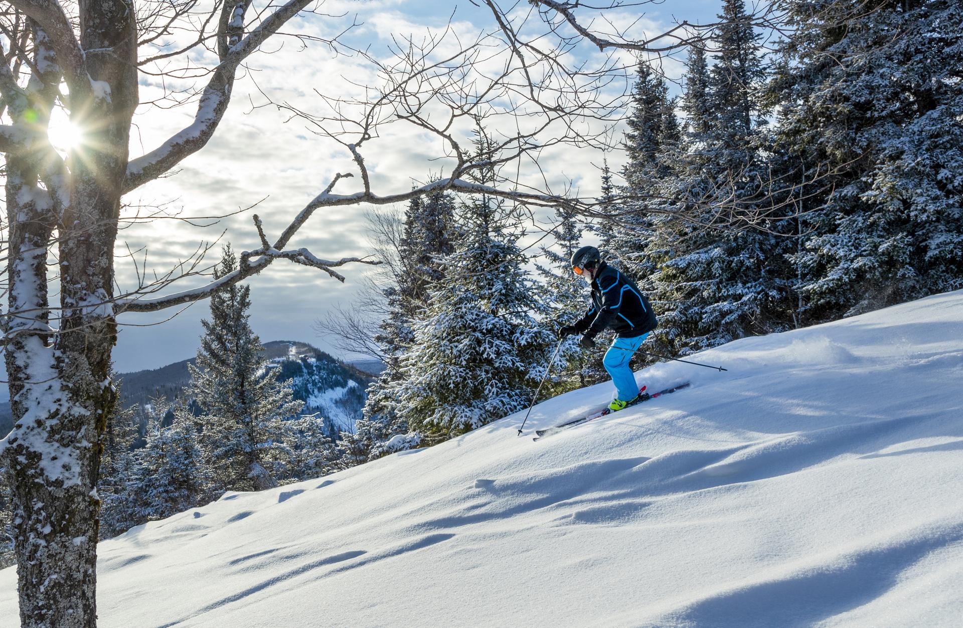 Lutsen Mountains in USA - a person riding a snowboard down a snowy slope.