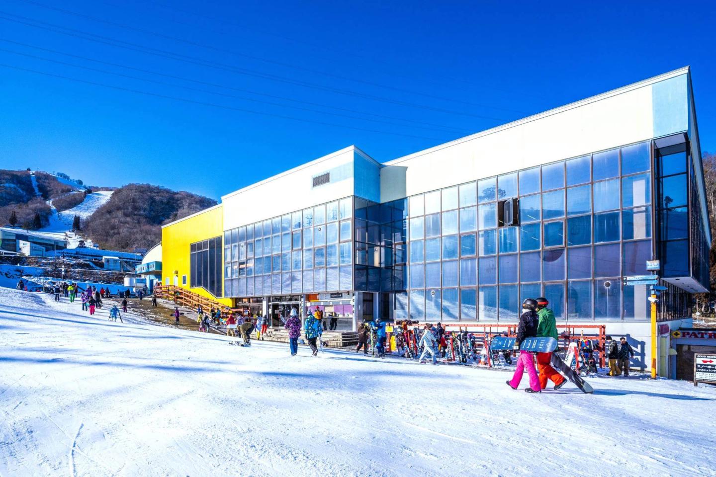 Dynaland in Japan - a group of people walking down a snow covered slope.