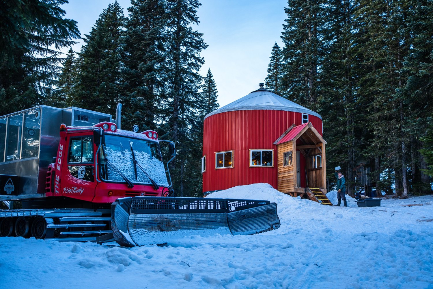 Cascade Powder Guides in USA: a red truck parked in the snow next to a red building.