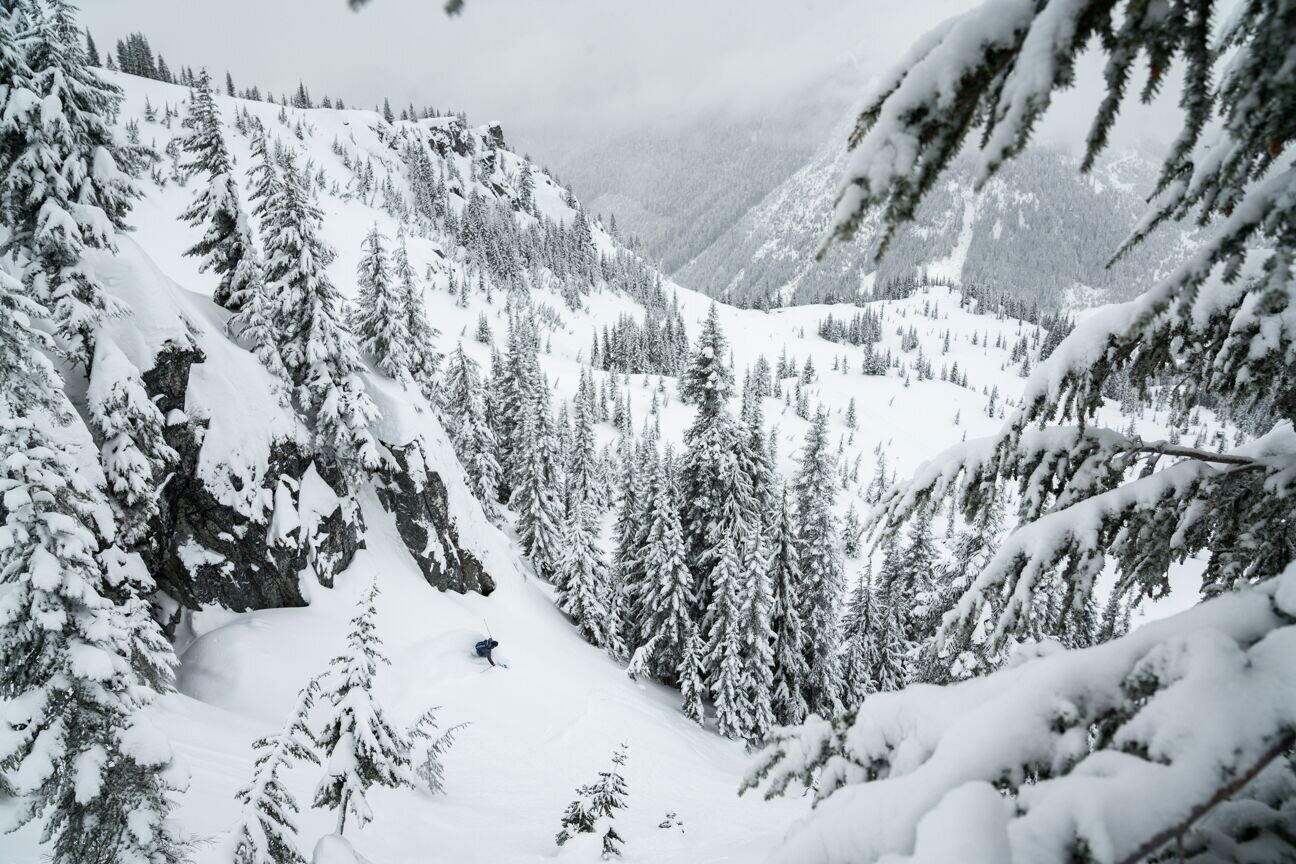 Cascade Powder Guides in USA - a person skiing down a mountain covered in snow.