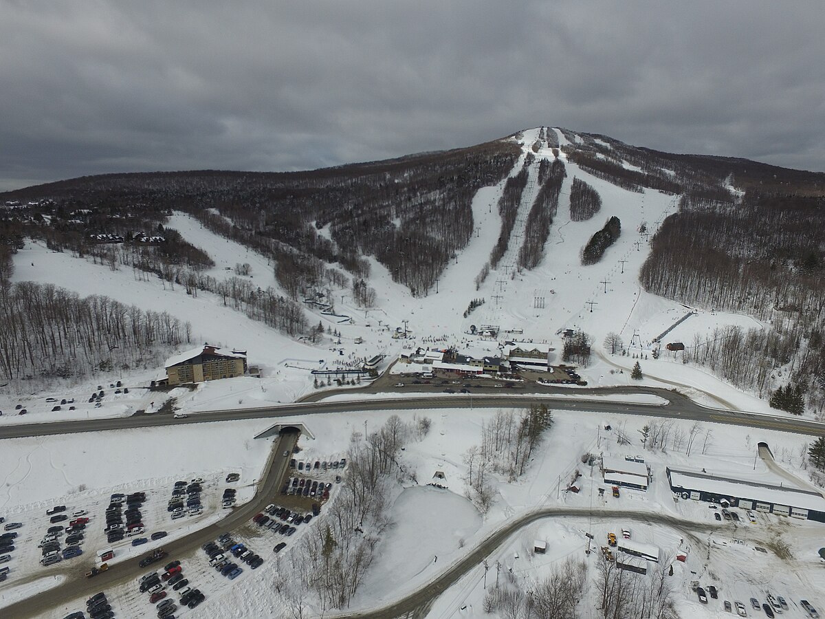 Bromley Mountain in USA - a snow covered ski slope with cars parked on it.
