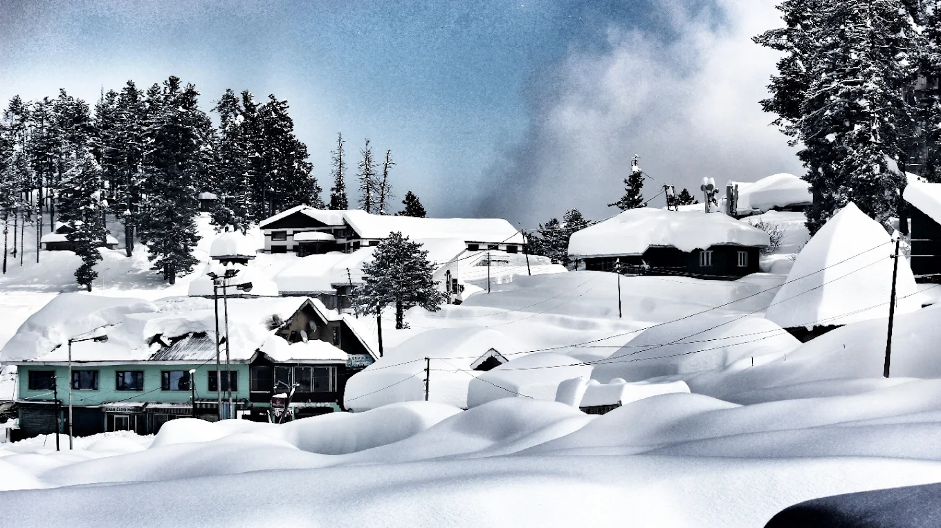 Gulmarg Ski Resort in India - a snowy scene with houses and trees.