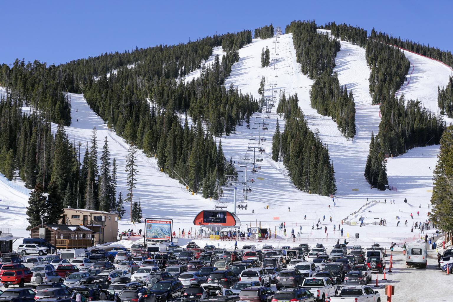 Eldora Mountain in USA - a parking lot filled with cars in front of a mountain.