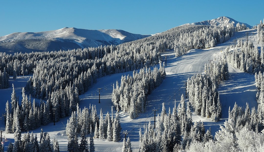 Eldora Mountain in USA - a snow covered mountain with trees in the fore.