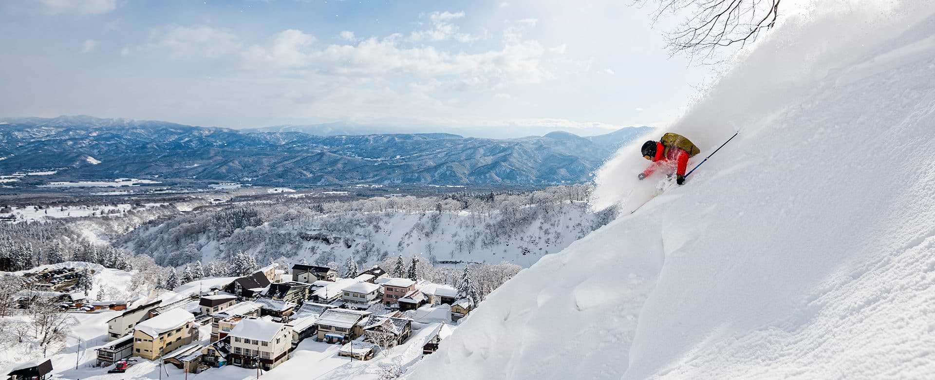 Seki Onsen in Japan - a person skiing down the side of a mountain.