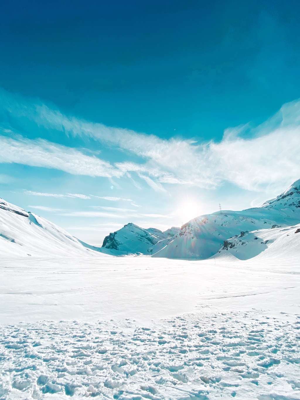 Winter sports scene in Leukerbad, Switzerland, showcasing a stunning winter and mountainous landscape blanketed in snow under clear skies.