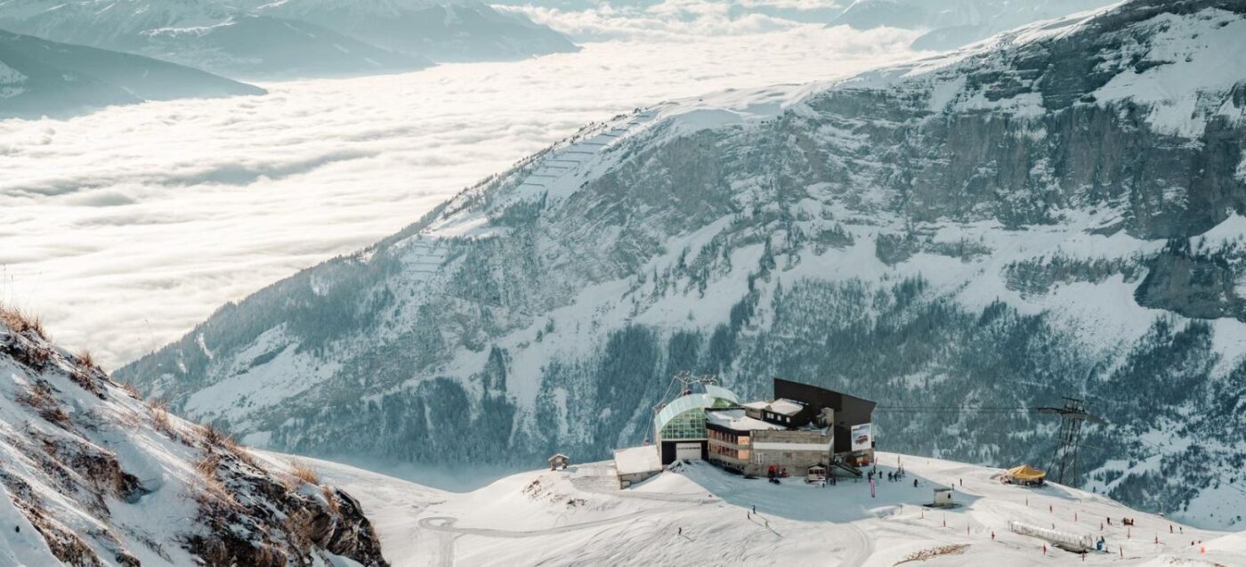 Leukerbad in Switzerland - a helicopter flying over a mountain covered in snow.