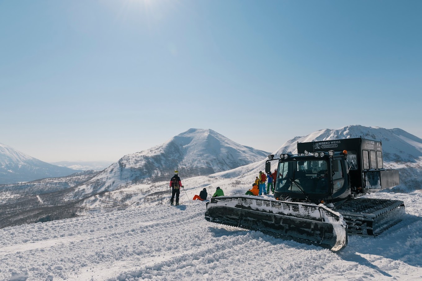 Winter sports scene at Niseko Weiss Cat in Japan featuring a snowmobile and a ski lift at a ski resort with stunning winter scenery.