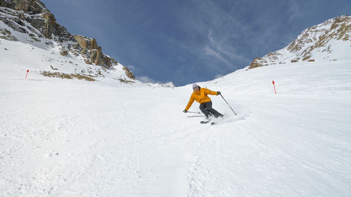 Pejo 3000 in Italy - a man in a yellow jacket skiing down a mountain.