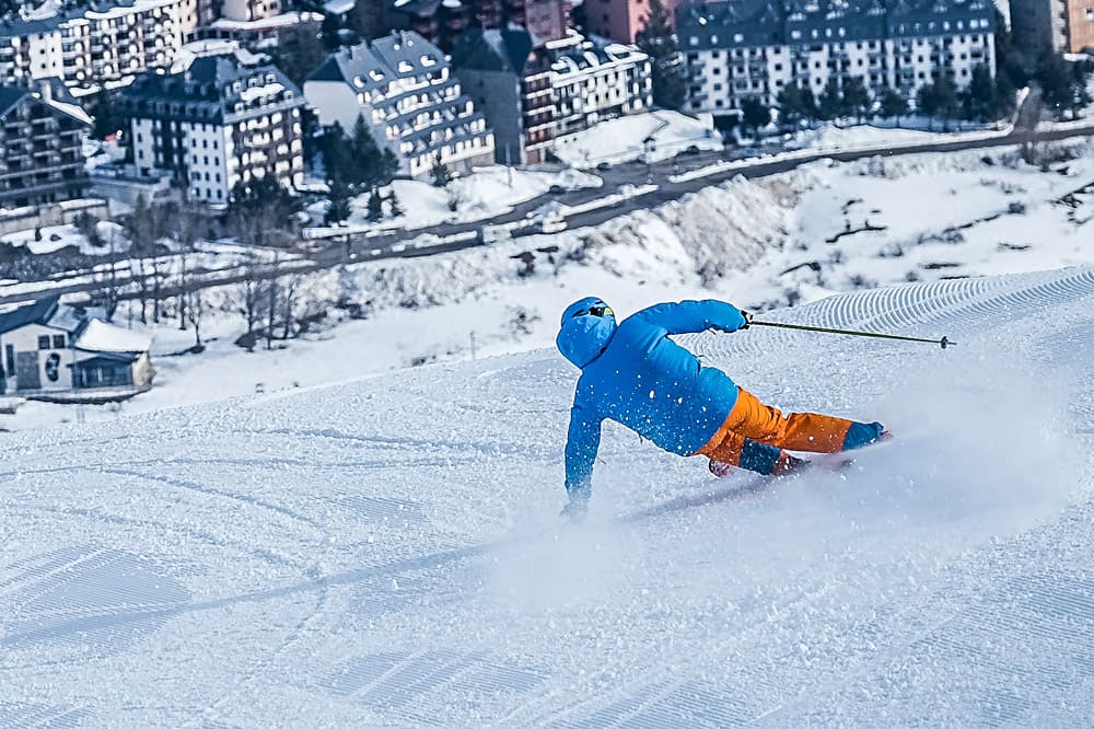 A skier enjoying a winter day in Panticosa, Aragon, Huesca, Spain. The scene is set in a busy ski resort, with people participating in various winter sports activities.
