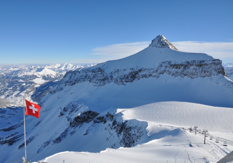 A skier gliding down a snowy slope at Glacier 3000 – Les Diablerets ski resort in Bern, Switzerland. Majestic mountains provide a stunning backdrop, a winter sports haven.