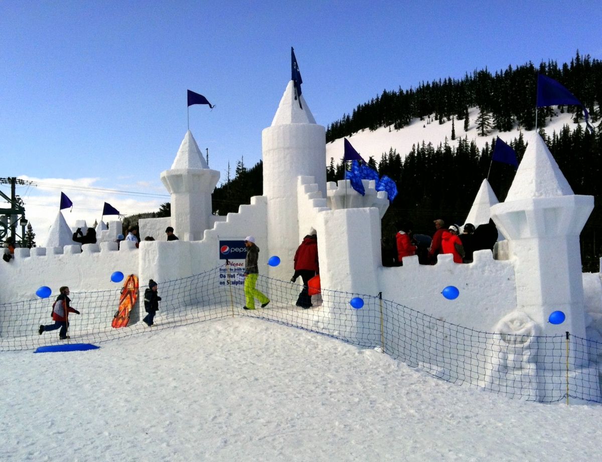 White Pass in USA - a group of people standing around a snow castle.