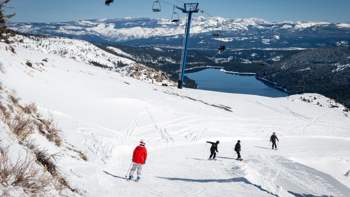 Donner Ski Ranch in USA - two people skiing down a mountain with a ski lift.