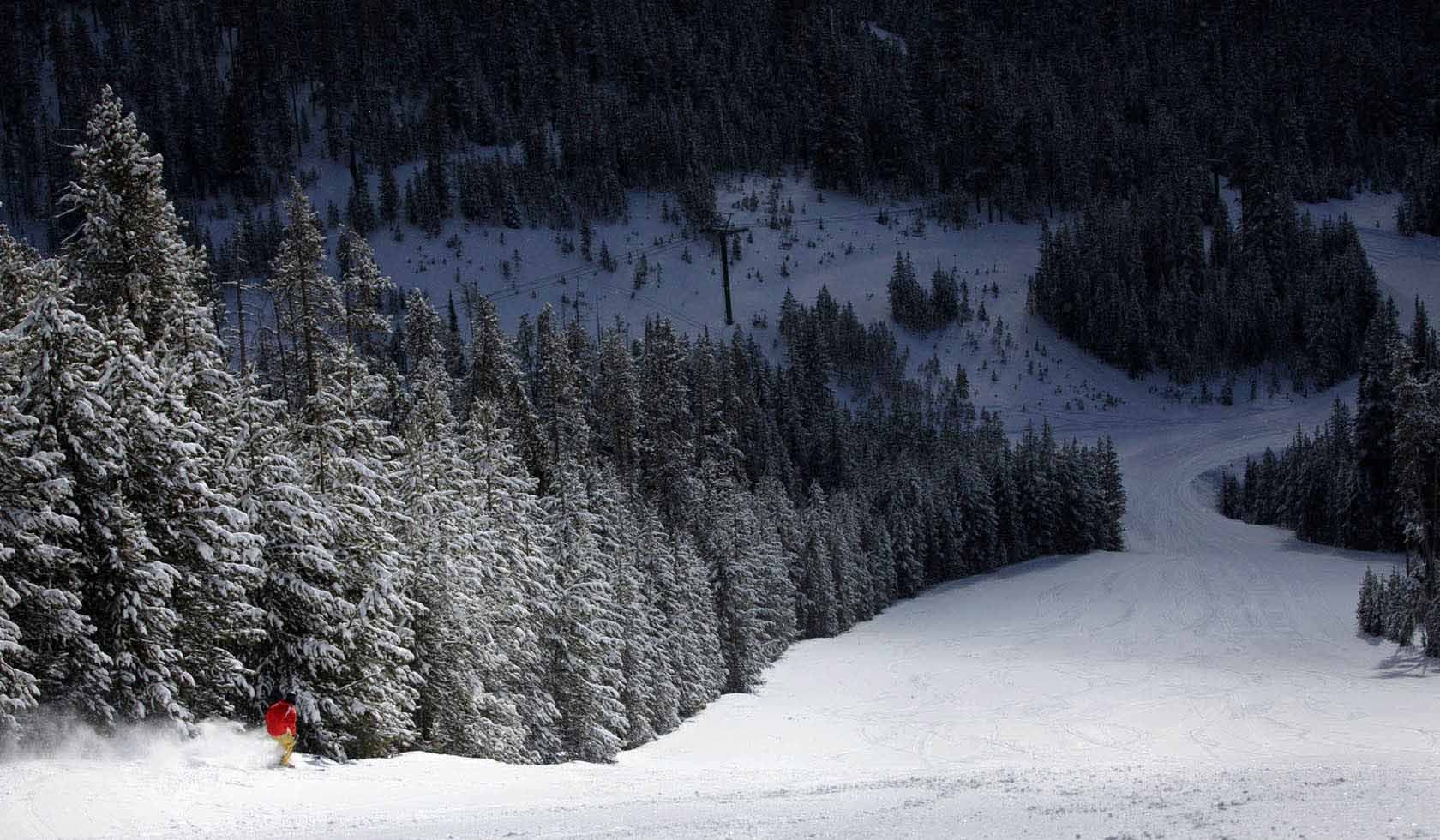 Discovery Ski Area in USA - a person riding a snowboard down a snowy slope.