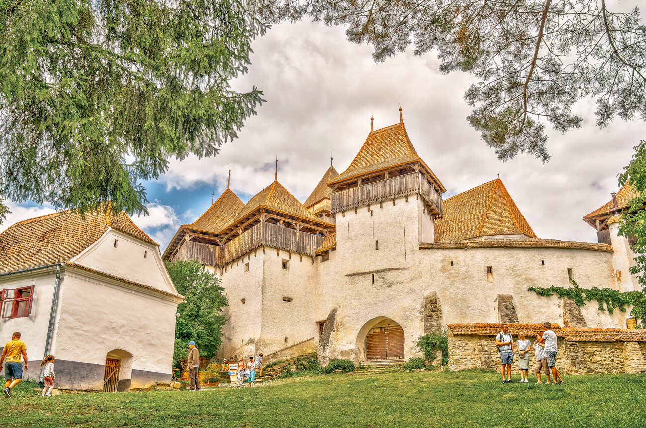 Transylvania Heliski in Romania - a group of people standing in front of a castle.
